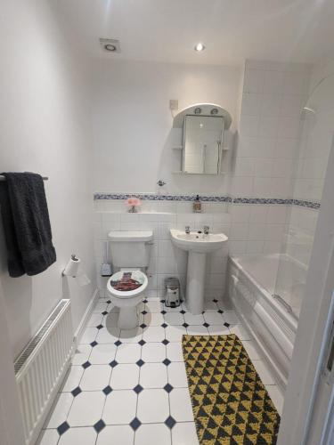a bathroom with a toilet and a sink and a tub at Stylish Modern Apartment, FREE SECURE Parking in Allesley