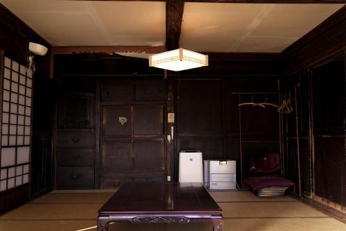an empty room with a table and a light at MAYUDAMAHOUSE in Higashiagatsuma