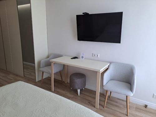 une chambre avec une table, deux chaises et une télévision dans l'établissement Dream Apartments at Alliance Palace, à Batoumi