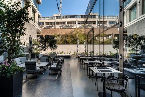 a restaurant with tables and chairs and a building at Publica Isrotel, Autograph Collection in Herzliya