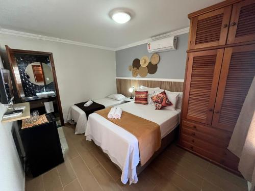 una camera d'albergo con due letti e uno specchio di Pousada dos Sonhos - MP a Miguel Pereira