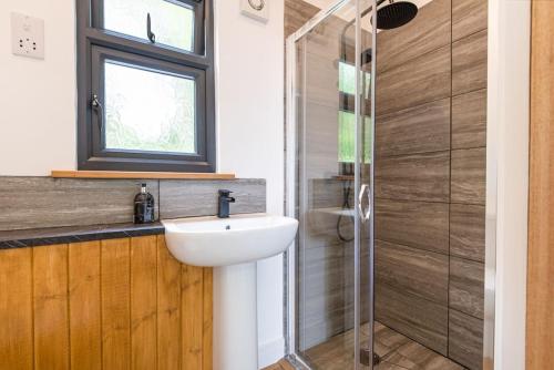 W łazience znajduje się umywalka i prysznic. w obiekcie The Cabin in the Tamar Valley. w mieście Gunnislake
