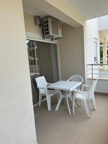 New Comfortable Apartment in Bijela - Appart numéro 2 في بييلا: طاولة بيضاء وكراسي على شرفة مع ميكروويف