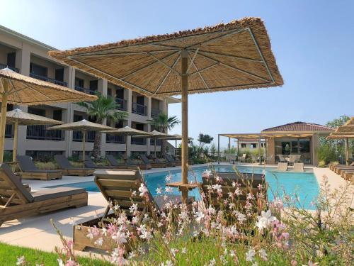 a resort with a swimming pool with chairs and umbrellas at Anassa Resort Halkidiki - Adults only in Kalivia Poligirou