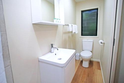 ein Badezimmer mit einem weißen Waschbecken und einem WC in der Unterkunft Chambers Wildlife Rainforest Lodges in Lake Eacham