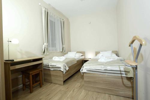 two beds in a small room with a mirror at Apartman Gondola in Győr