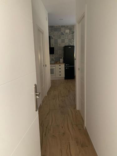 un corridoio che conduce a una cucina con pavimento in legno di Apartamentos el Sabinar a Anchuela del Campo