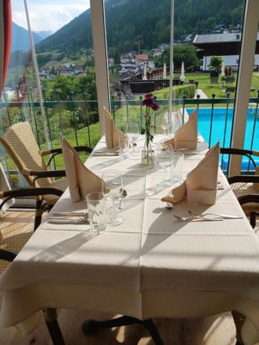 a table with glasses and napkins on a table with a view at Hotel Habicht in Fulpmes