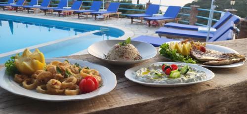 una mesa cubierta con platos de comida junto a una piscina en Itaka Hotel Lukova, en Lukovë
