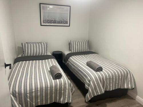 two beds sitting next to each other in a room at Ocean View - Alexandra Headlands Beachfront Unit in Alexandra Headland