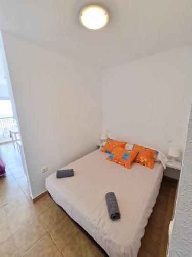 - une chambre dotée d'un lit avec des oreillers orange dans l'établissement Apartamento Albatros Beach-6, à Empuriabrava