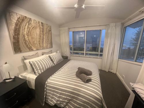 un dormitorio con una cama con un animal de peluche en Ocean View - Alexandra Headlands Beachfront Unit, en Alexandra Headland