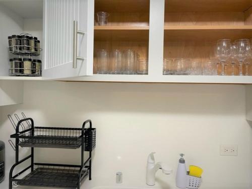 a kitchen with white cabinets and a sink with glasses at Waikiki Condo 2 Bedrooms 2 Bathrooms with 1 free parking space in Honolulu