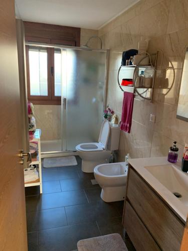 een badkamer met 2 toiletten, een douche en een wastafel bij Acogedora casa de campo,muy cómoda in Ourense
