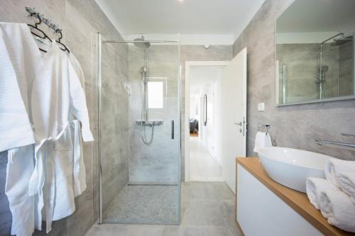 a bathroom with a glass shower and a sink at Sea you Soon by the beach, 2-bedrooms suite in Seget Donji in Trogir