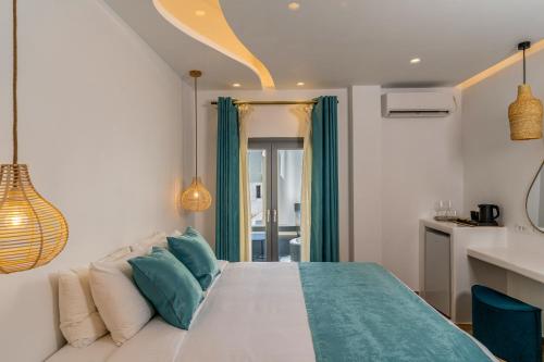 a bedroom with a large bed with blue pillows at Kafieris View in Firostefani