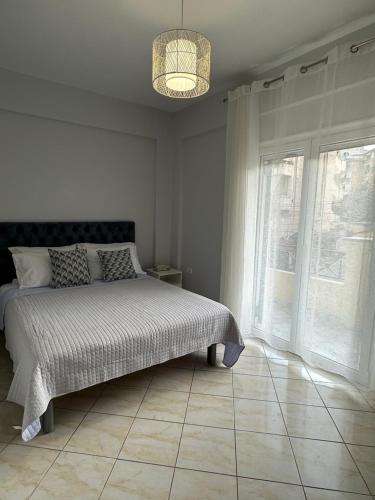 a bedroom with a bed and a large window at Saranda Apartments in Sarandë