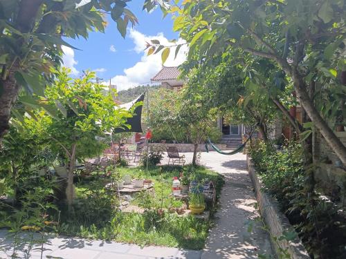 a garden in front of a house with trees at Kevin's Trekker Inn in Shangri-La