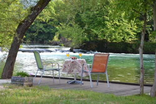 a table and chairs on a dock next to a river at Villa River and Sky in Bihać