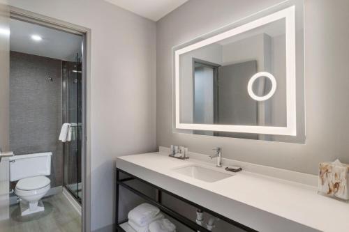 uma casa de banho com um lavatório, um espelho e um WC. em Houston Marriott North em Houston