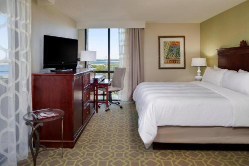 チャールストンにあるCharleston Marriottのベッドと薄型テレビがあるホテルの部屋