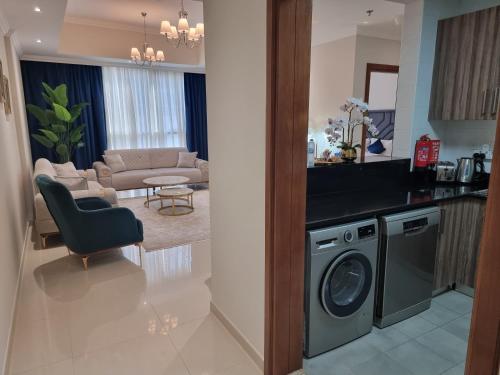 uma cozinha e sala de estar com máquina de lavar roupa em Dunya Tower Luxury and 2 min walk to Dubai Mall and Burj Khalifa em Dubai