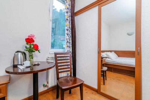 a small table and chair in a room with a bed at EcoRest - Likani Palace in Borjomi
