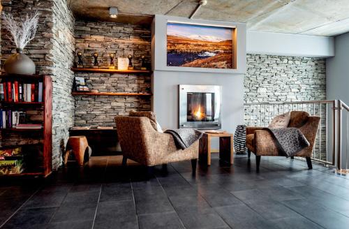 a living room with two chairs and a fireplace at Havsdalsgrenda Geilo Apartments in Geilo
