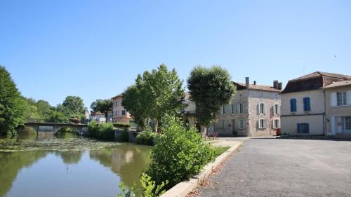 a street in a town with a river and buildings at 18 on the Rue in Eymet
