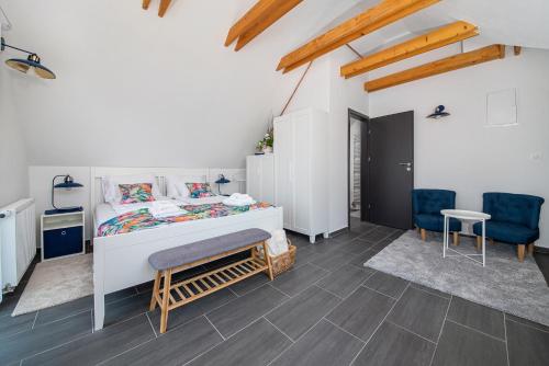 1 dormitorio con 1 cama y 2 sillas azules en Papoula Vendégház, en Tihany