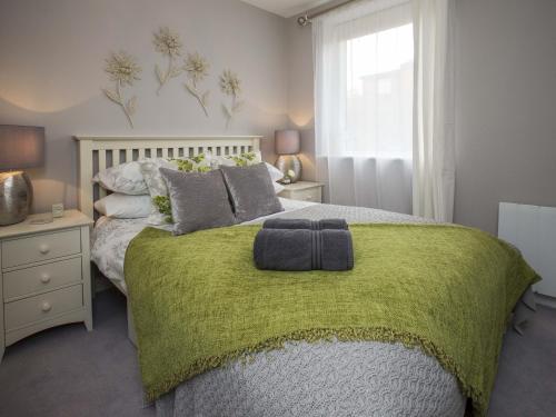a bedroom with a bed with a green blanket on it at Portland View in Bristol