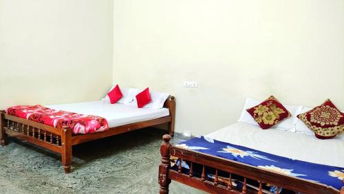two beds sitting in a room with at Kurumbalakotta Village Homestay in Padinjarathara