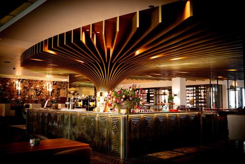 a restaurant with a bar with flowers on it at Van der Valk Hotel Nuland - 's-Hertogenbosch in Nuland