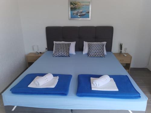 a large blue bed with two pillows on it at Apartman Klara in Karlobag