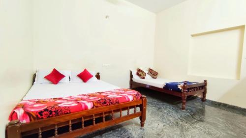 um quarto com 2 camas e almofadas vermelhas em Kurumbalakotta Village Homestay em Padinjarathara