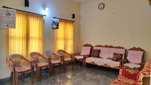 a room with a bunch of chairs and a table at Kurumbalakotta Village Homestay in Padinjarathara