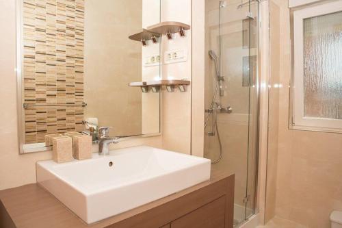 a bathroom with a white sink and a shower at Apartmani Miš Rab in Palit