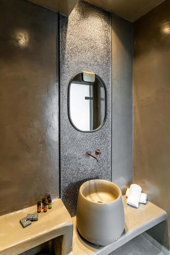 a bathroom with a round toilet and a mirror at Kafieris View in Firostefani