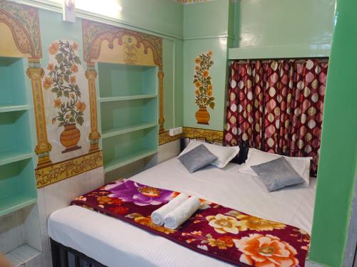 Musa's Homestay في جودبور: غرفة نوم بسرير مع شراشف بيضاء وزهور