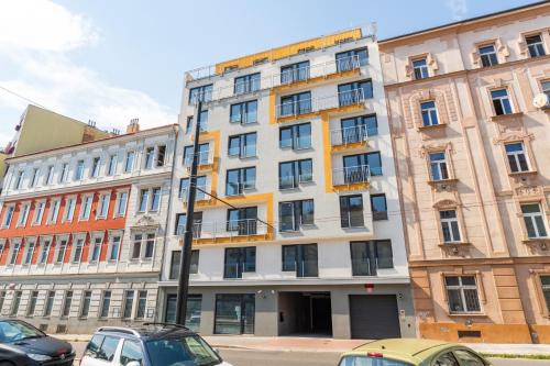 um edifício alto com carros estacionados em frente em Brand new two room apartment #64 in Elite Rezidence with free secure parking em Praga