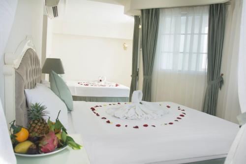a room with two beds with a bowl of fruit at Pavillon Garden Hotel in Nha Trang
