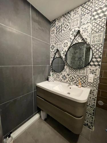 une salle de bain avec un lavabo et un miroir dans l'établissement Appartement à 250m de la mer, à Saint-Raphaël