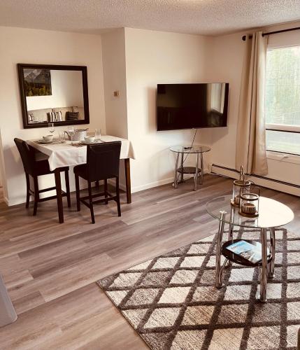 a living room with a table and a tv at North Star Place 11 in Fairbanks