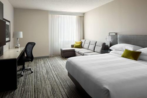 um quarto de hotel com uma cama grande e um sofá em Marriott Cincinnati Northeast em Mason