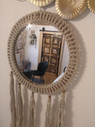 a large round mirror with a rope frame on a wall at The Little Blue House in Reşiţa