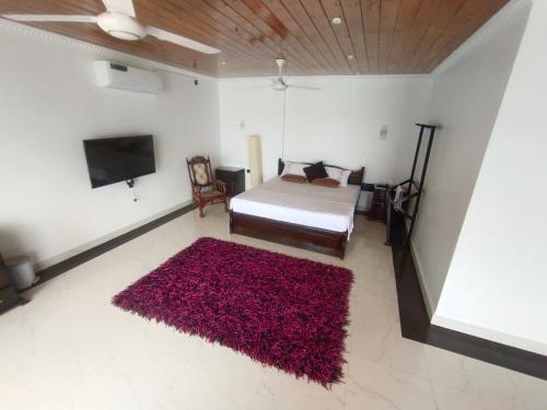 a bedroom with a bed and a red rug at Sellamah beach Hotel in Trincomalee