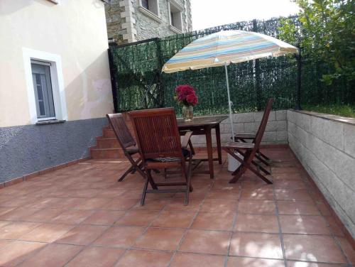 a patio with a table and chairs and an umbrella at Casa Rural en CADAVEDO LUARCA ASTURIAS in Villademoros