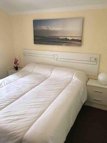 a bedroom with two beds and a painting on the wall at Casa Rural en CADAVEDO LUARCA ASTURIAS in Villademoros