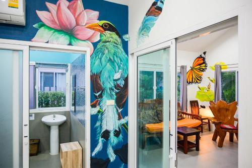 a bathroom with a painting of a bird on the wall at Chill Out Village in Ao Nam Mao