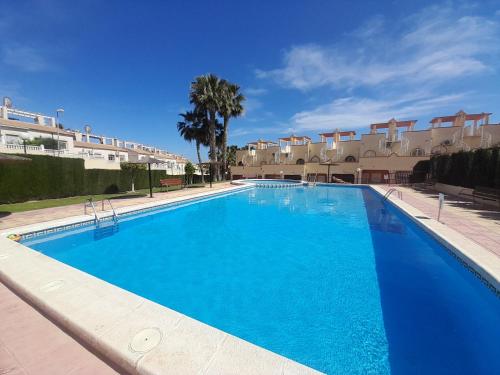 een groot blauw zwembad voor sommige appartementen bij Villa Casa Max - duplex-apartment in Villamartin Golf Resort in Villamartin